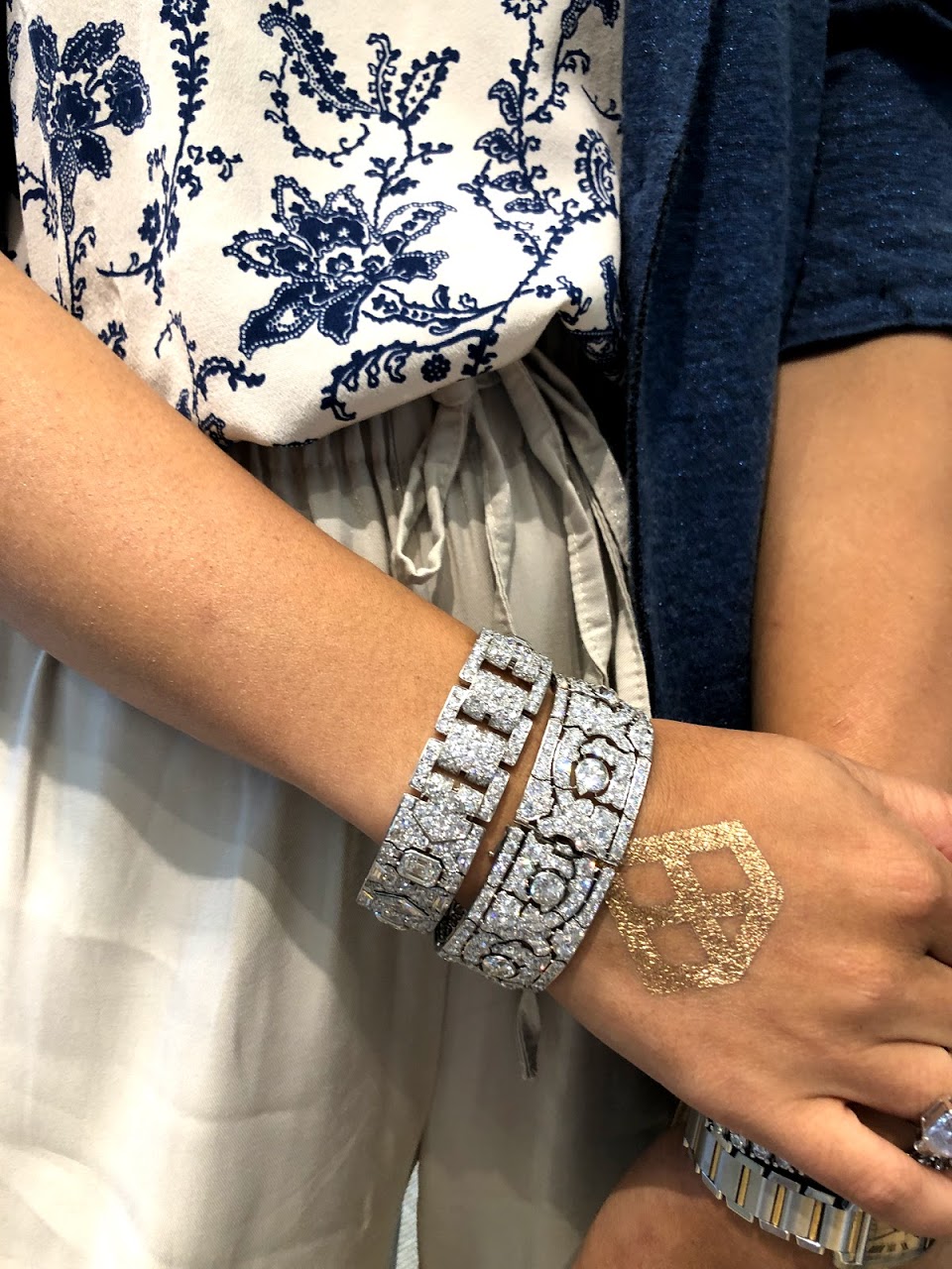 Gem X member wearing two diamond bracelets and Gem X logo on hand.